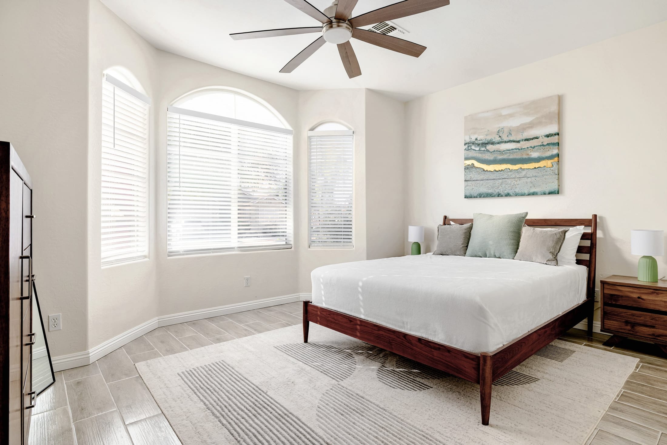 Guest-ready bedroom with arched windows in an Airbnb we clean