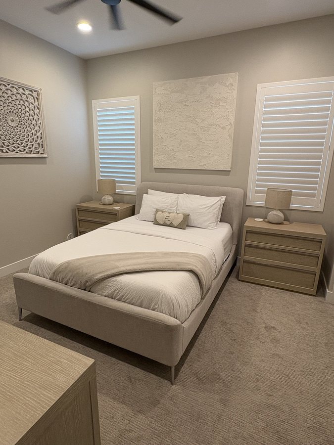 Guest bedroom cleaned with the bed made and floors vacuumed