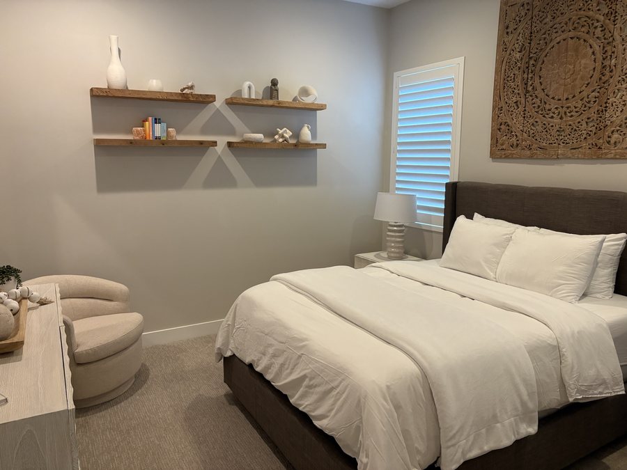 Bedroom with open shelving dusted and the bed remade after a clean