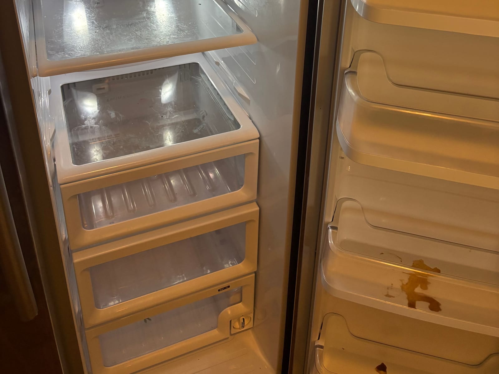 Refrigerator interior with spills and residue before a move-out cleaning