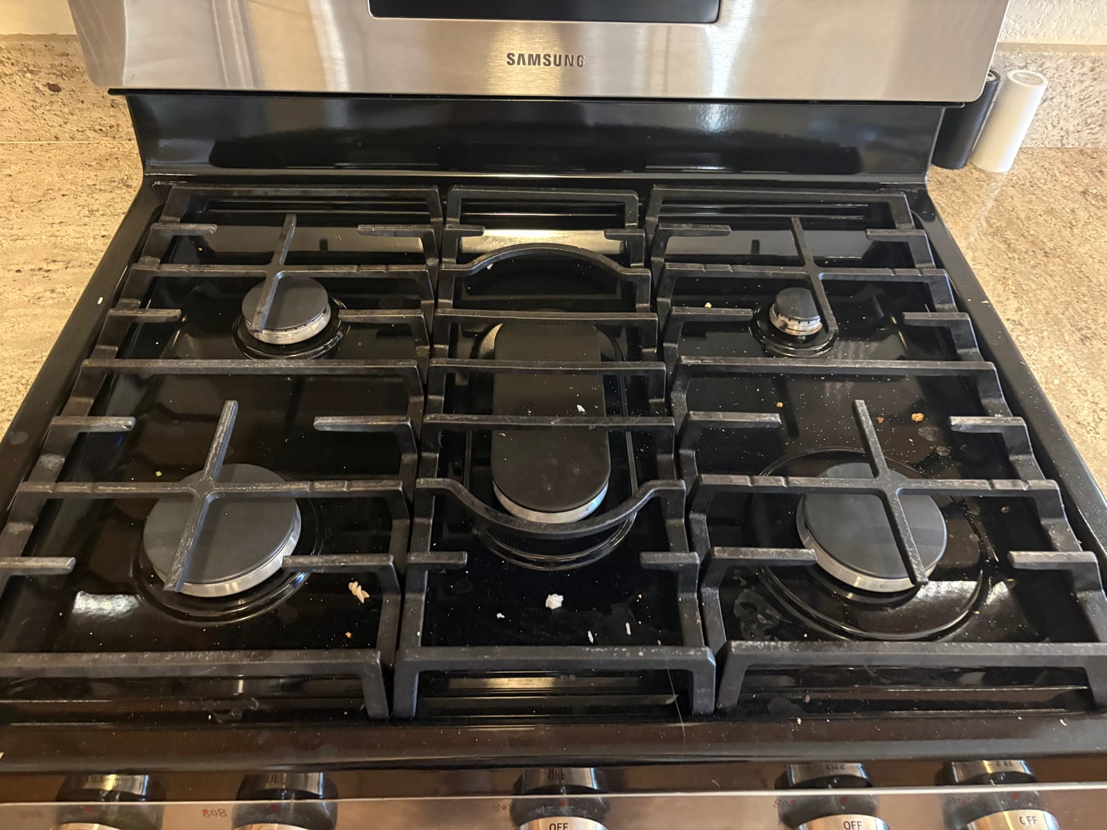 Gas stove with grease and food debris before a move-out cleaning