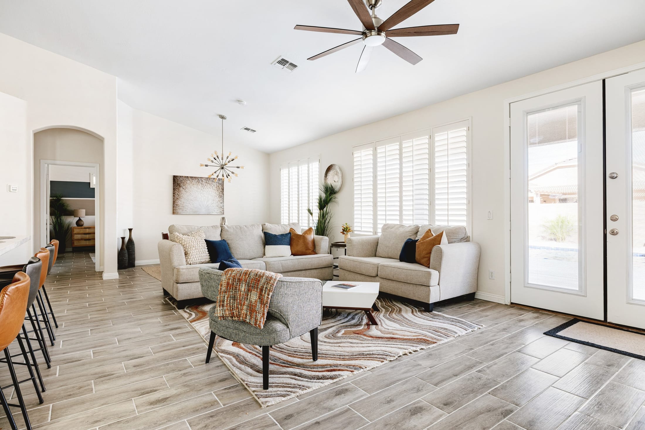 Bright, spotless living room of a vacation rental we clean, opening to the pool