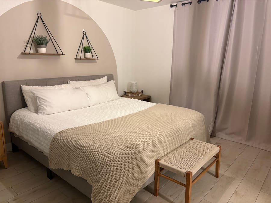 Guest bedroom in an arched alcove, remade for a family stay after a turnover clean